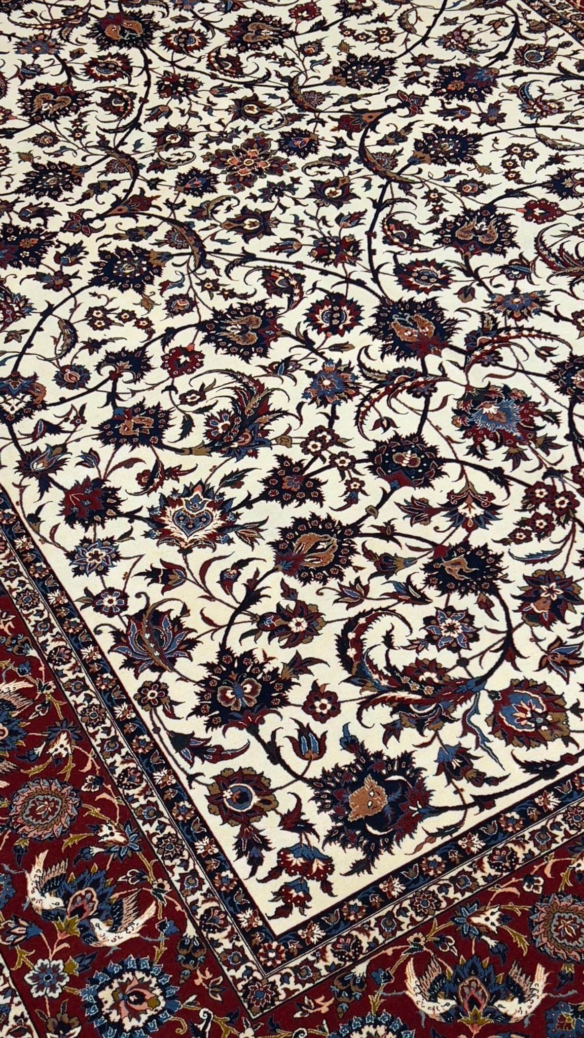 Antique Persian rug with red and beige floral patterns, hand-knotted in Isfahan, Iran
